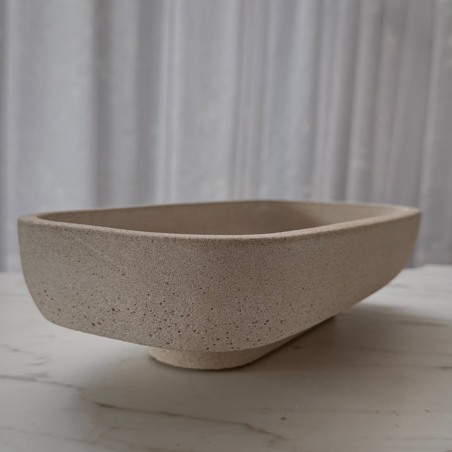 Handcrafted Monolith pedestal featuring a solid yet minimalist rectangular form with a natural stone-inspired finish and rounded corners.