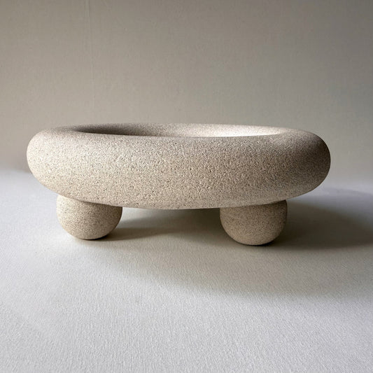 Handcrafted Halo Footed Bowl featuring a warm natural stone finish and rounded sculptural feet.