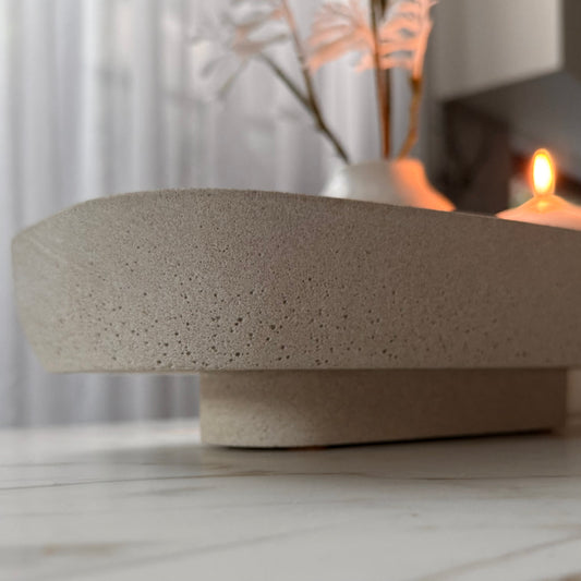 A close up view of handcrafted Monolith pedestal featuring a solid yet minimalist rectangular form with a natural stone-inspired finish and rounded corners. 