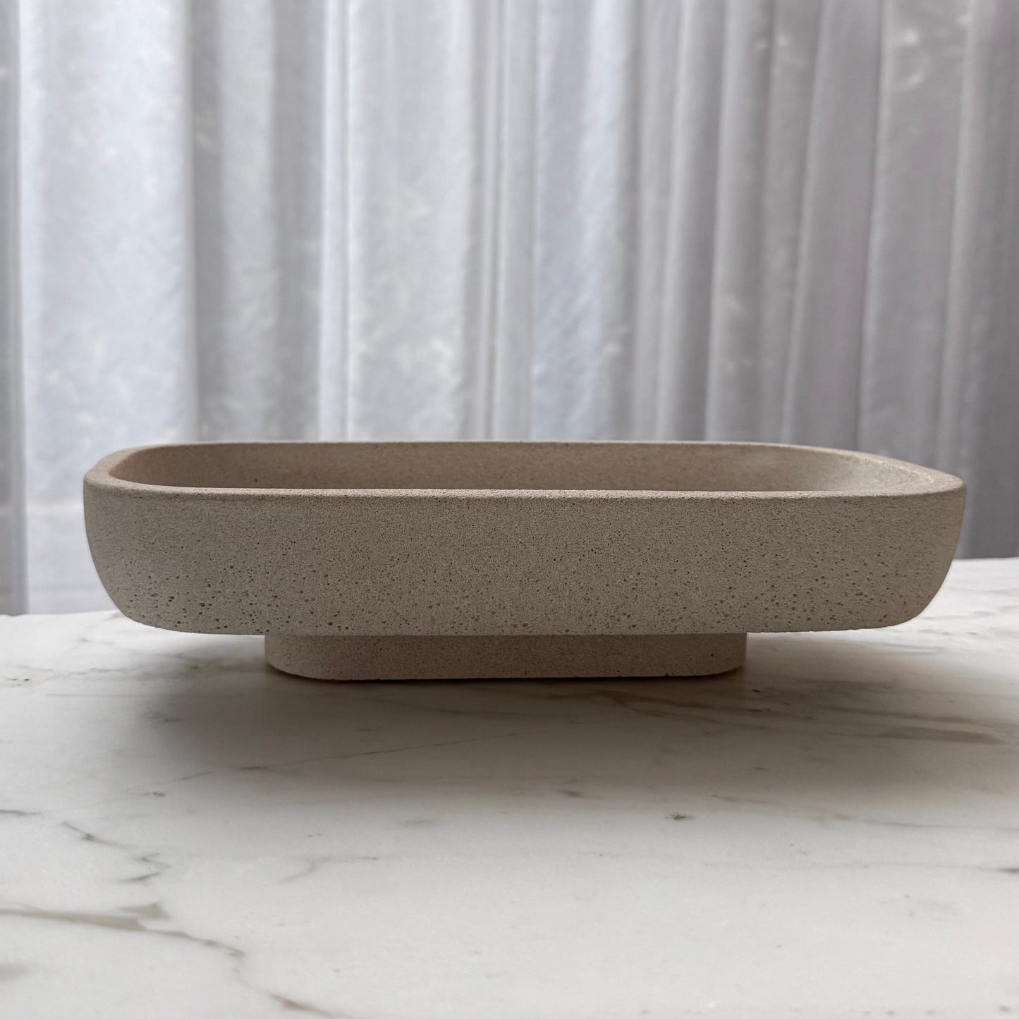 Handcrafted Monolith pedestal featuring a solid yet minimalist rectangular form with a natural stone-inspired finish and rounded corners. 