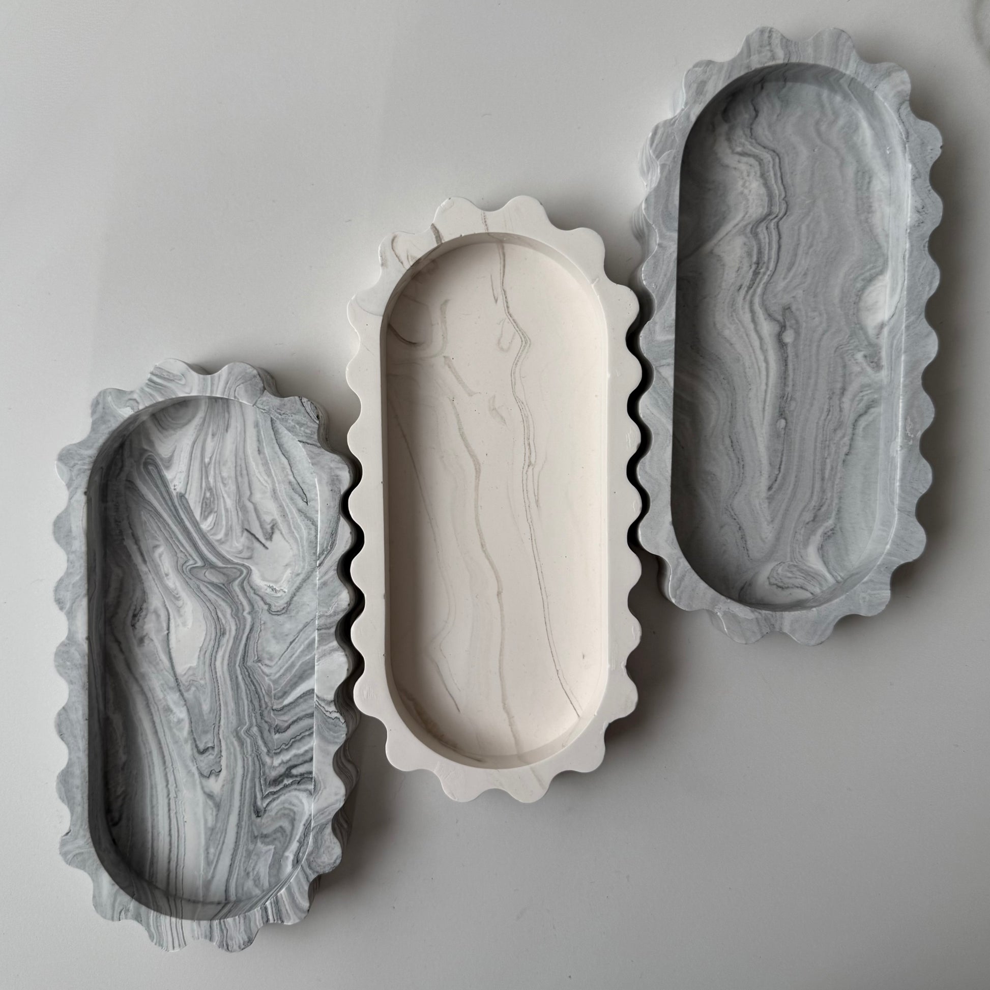 Overhead view of three handcrafted Tide Trays highlighting the collection's sculptural silhouette and contrasting finishes.