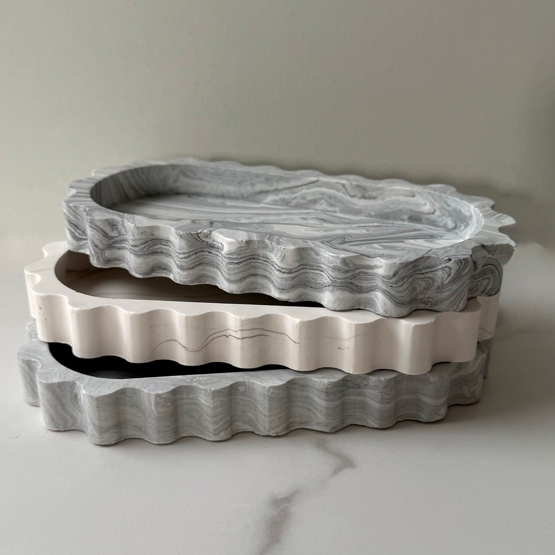 Three stacked handcrafted Tide Trays showcasing their rippled profile and highlighting the collection's contrasting stone-inspired finishes.